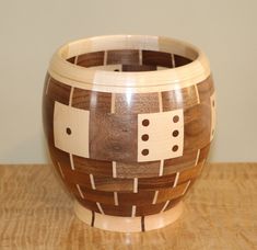 a wooden bowl sitting on top of a table next to a white wall and wood floor