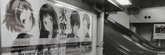 an escalator in a subway station with posters on the wall