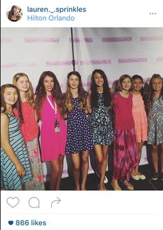 a group of young women standing next to each other in front of a white wall