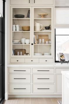 a kitchen with white cabinets and black appliances