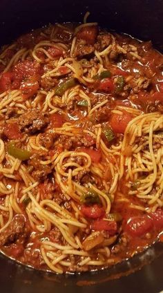 a pan filled with spaghetti and meat in tomato sauce