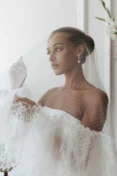 a woman wearing a veil and dress in front of a mirror