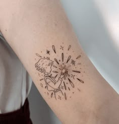 a woman's arm with a tattoo on it that has fireworks coming out of it