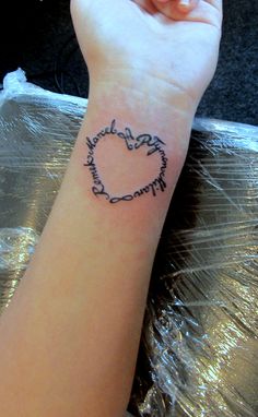 a person with a heart tattoo on their wrist