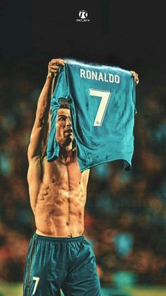 a shirtless man holding up a jersey in front of his face with the number seven on it