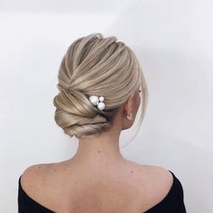 a woman with her hair in a low bun and two pearled clip pins on the back of her head