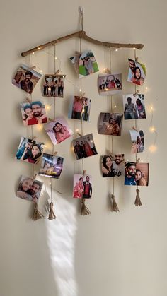 a bunch of pictures hanging on a wall with lights around them and some string attached to it