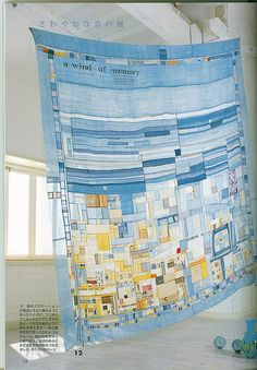 a large blue and yellow quilt hanging from the ceiling