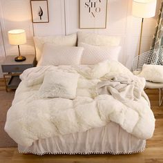 a bed with white comforter and pillows in a room