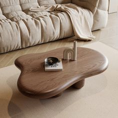 a wooden table sitting on top of a carpeted floor next to a white couch