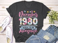 a t - shirt with the words november 1960 born to be awesome on it next to jeans