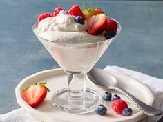 a dessert dish with whipped cream, strawberries and blueberries