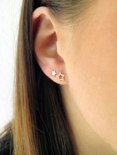 a woman's ear with two small stars on the top and bottom of it