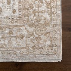 an area rug on a wooden floor with a brown and white color scheme in the middle