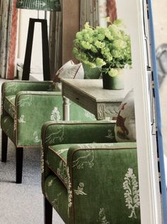 an image of a living room setting with green furniture and flowers in vases on the table