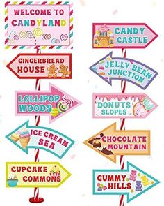 a bunch of signs that are hanging on a pole with candy land written on them