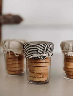 three jars filled with cookies sitting on top of a table