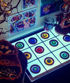 an illuminated board game with circles on it and other items in front of the screen