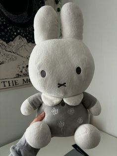 a white stuffed rabbit sitting on top of a desk