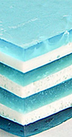 three pieces of blue and white cake sitting on top of each other, with water droplets all over them