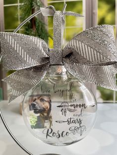 a glass ornament with a dog's name and a bow on it