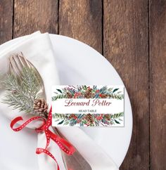 a white plate topped with a fork and knife next to a red ribbon tied around it