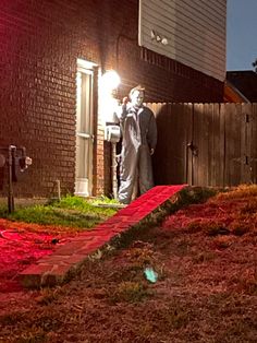 a man standing in front of a house at night