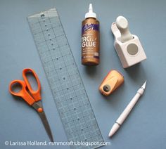 craft supplies laid out on top of a blue surface next to a ruler and pen