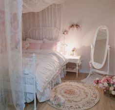 a white bed sitting in a bedroom next to a mirror