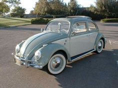 an old vw bug parked in a parking lot