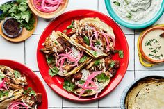 mexican food on red plates with sauces and pita bread