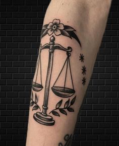 a tattoo on the arm of a lady justice scale