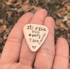 a hand holding a small wooden guitar pick with writing on it that says, if pack you every time