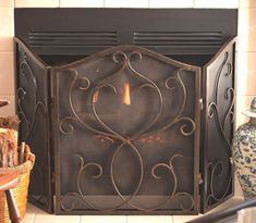 a fire place sitting in the middle of a living room next to a basket and vase