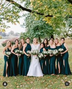 a group of women standing next to each other on top of a grass covered field