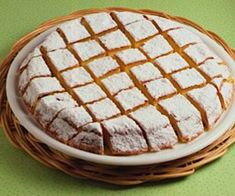 a cake sitting on top of a white plate next to a green tablecloth covered floor