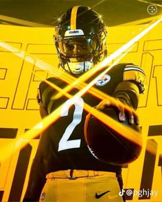 a football player holding a ball in front of a yellow background with the number 2 on it