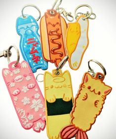 four different colored key chains with cats and fish on them