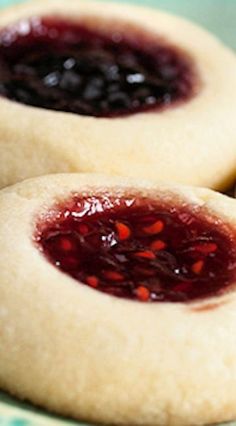 two cookies with jelly filling on them sitting on a plate