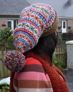 a woman wearing a multi colored knitted hat