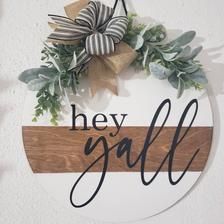 a wooden sign that says hey y'all hanging on the side of a wall