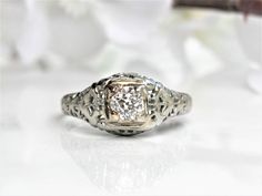 an antique style diamond ring with filigrees