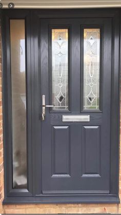 a black front door with two sidelights and glass panels on the top half of it