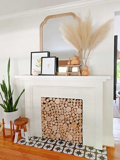 a living room with a fire place, mirror and potted plant on the mantel