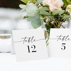 the table numbers are displayed in vases with flowers