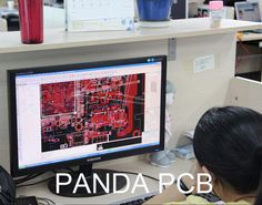 a woman sitting in front of a computer monitor