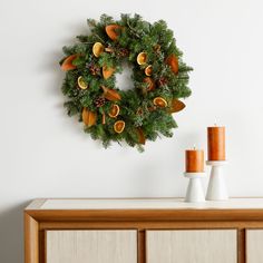 a wreath is hanging on the wall above a dresser