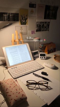 an open laptop computer sitting on top of a desk next to glasses and other items