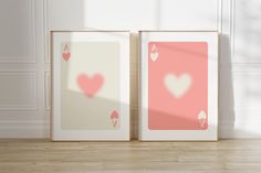 two framed pictures with hearts on them sitting next to each other in front of a white wall