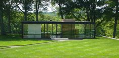 a glass house sitting on top of a lush green field